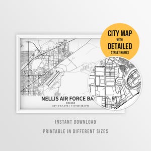 May include: A black and white map print of Nellis Air Force Base, Nevada, featuring coordinates 36°14'57.0"N | 114°59'46.0"W. A circular inset shows a magnified view of the street layout. Text includes CITY MAP WITH DETAILED STREET NAMES.