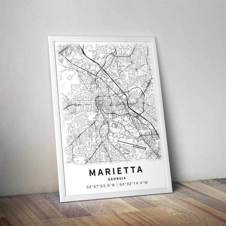 Może przedstawiać: Oprawiony wydruk artystyczny przedstawiający czarno-białą mapę ulic Marietta w stanie Georgia. Wydruk zawiera nazwę miasta, stan oraz wsp&oacute;łrzędne geograficzne 33&deg;57'02.0"N | 84&deg;32'14.4"W zapisane bezszeryfową czcionką u dołu grafiki.