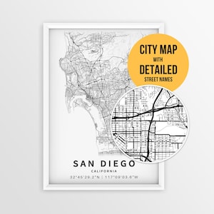 May include: A framed black and white map print of San Diego, California, featuring a detailed street grid and coordinates. A circular inset highlights specific street names, and a yellow circle contains the text CITY MAP WITH DETAILED STREET NAMES.