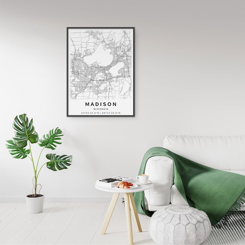 May include: A framed black and white map print of Madison, Wisconsin, featuring detailed street grids and water bodies. The text below the map reads MADISON, WISCONSIN, followed by the geographic coordinates 43&deg;04'25.8"N | 89&deg;23'28.9"W.