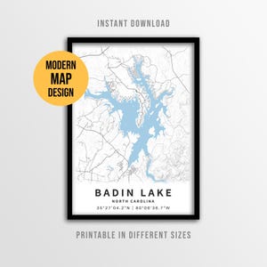 May include: A framed map print of Badin Lake, North Carolina, featuring light blue water against a white background with black road lines. The text reads BADIN LAKE, NORTH CAROLINA, 35°27'04.2"N | 80°06'36.7"W, MODERN MAP DESIGN, INSTANT DOWNLOAD.