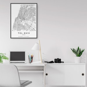 May include: A framed black and white map print of Tel Aviv, Israel. The print includes the city's name, country, and coordinates. The map is detailed, showing streets and urban areas.