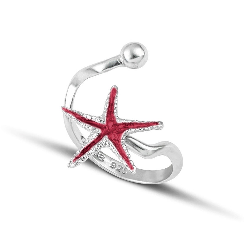 a silver ring with a red starfish on it