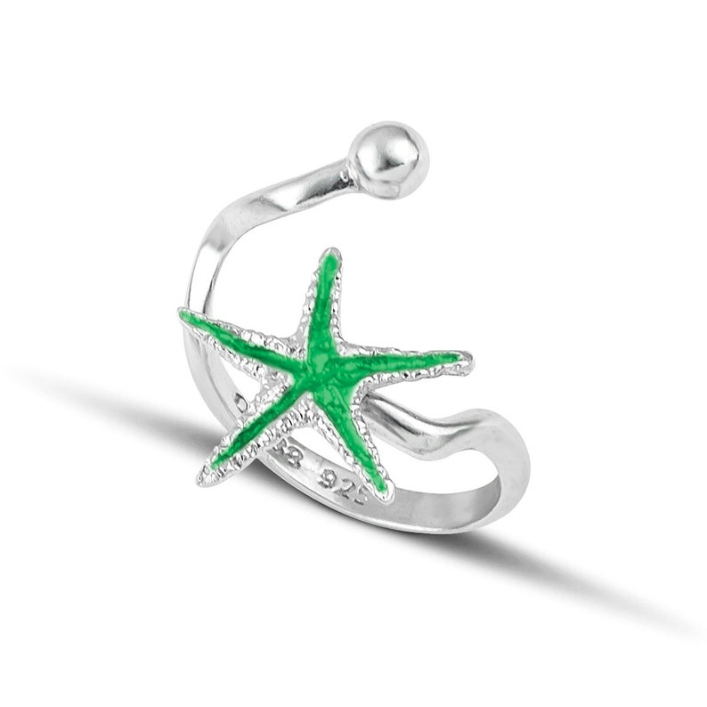 a silver ring with a green starfish on it