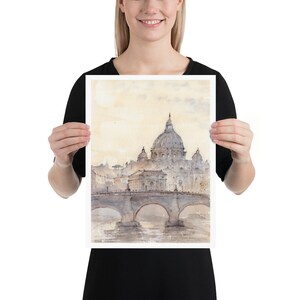 Peut inclure: Une peinture &agrave; l'aquarelle de la basilique Saint-Pierre de Rome, en Italie. La peinture repr&eacute;sente la basilique de loin, avec un pont au premier plan et le Tibre en arri&egrave;re-plan. Le ciel est d'un jaune doux, et la basilique est d'un gris clair.