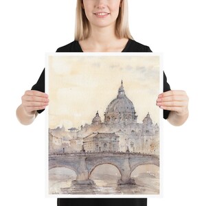 Peut inclure: Une peinture &agrave; l'aquarelle de la basilique Saint-Pierre de Rome, en Italie. La peinture repr&eacute;sente le d&ocirc;me de la basilique, le pont devant elle et l'horizon de la ville en arri&egrave;re-plan. La peinture est r&eacute;alis&eacute;e dans des tons de gris, de bleu et de blanc.