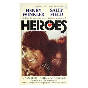 May include: A vintage paperback book cover for "Heroes" by James Carabatsos, featuring Henry Winkler and Sally Field. The cover has a warm color palette with a photo of the actors and the title in bold letters. The book is based on a screenplay.