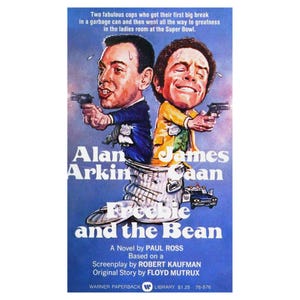 以下が含まれることがあります： 映画「フリービーとビーン」のポスター。アラン・アーキンとジェームズ・カーンが銃を構えた風刺画が描かれています。タイトルは大きく様式化されたフォントで、あらすじとクレジットが記載されています。背景は青色のグラデーションです。