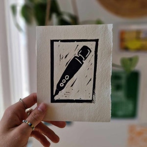 May include: A black and white linocut print of a microphone on a white background.