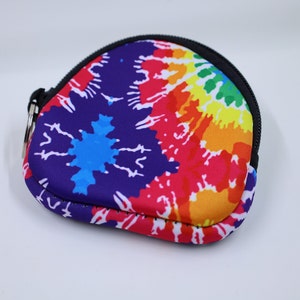 May include: A small, heart-shaped coin purse with a zipper closure. The purse is made of a soft, colorful fabric with a tie-dye pattern in shades of blue, red, yellow, and orange.