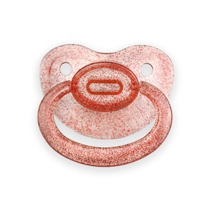 May include: A red glitter pacifier with a clear silicone ring. The pacifier is designed for babies and toddlers.