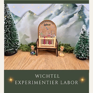 Könnte beinhalten: Ein Miniatur-Holzstuhl mit einer Korkwand, auf der kleine Glasfläschchen mit bunten Flüssigkeiten ausgestellt sind. Der Stuhl ist Teil einer skurrilen Laborszene, mit zwei kleinen Glasflaschen und zwei Miniatur-Weihnachtsbäumen. Der Text "EXPERIMENTIER labor" ist sichtbar.