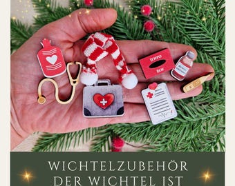 Può includere: Un set di decorazioni natalizie in legno a tema rosso e bianco. Le decorazioni includono un termometro, un kit di pronto soccorso, una bottiglia di medicina, uno stetoscopio, una sciarpa rossa e una cartella medica. Il testo sulle decorazioni recita "Wichtelzubehör Der Wichtel Ist Krank".