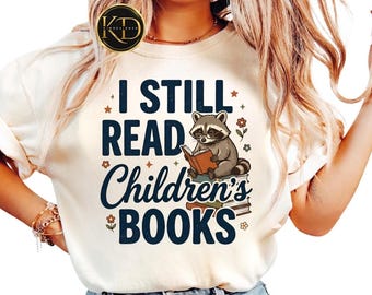 Camiseta "Todavía leo libros infantiles" de Comfort Colors, ideal para amantes de los libros, con un lindo mapache leyendo. Regalo perfecto para bibliotecarios.