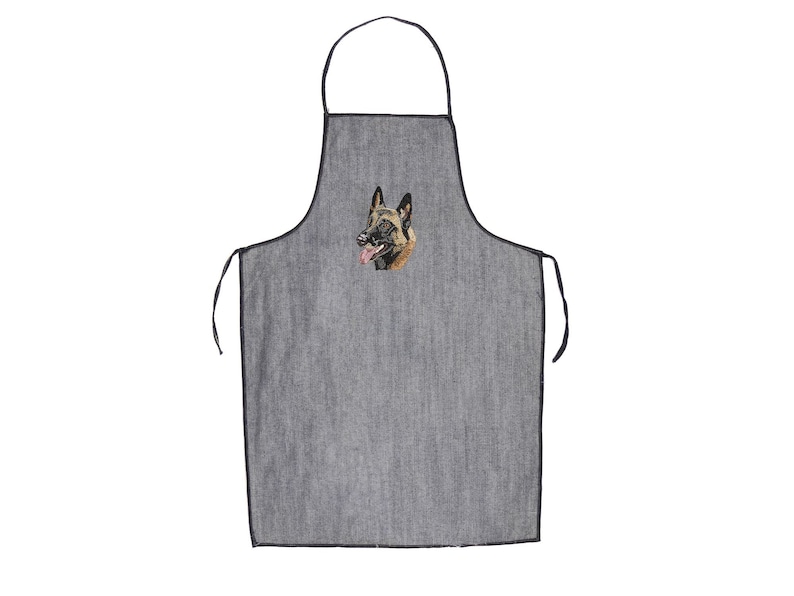 May include: Grey apron with an embroidered Belgian Malinois dog. The apron has black trim and ties. The dog's head is detailed with brown, black, and tan colours, with its tongue sticking out.