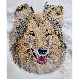 May include: Embroidered portrait of a dog's head, featuring a brown and white collie with a pink tongue sticking out. The dog's fur is detailed with different shades of brown and white.