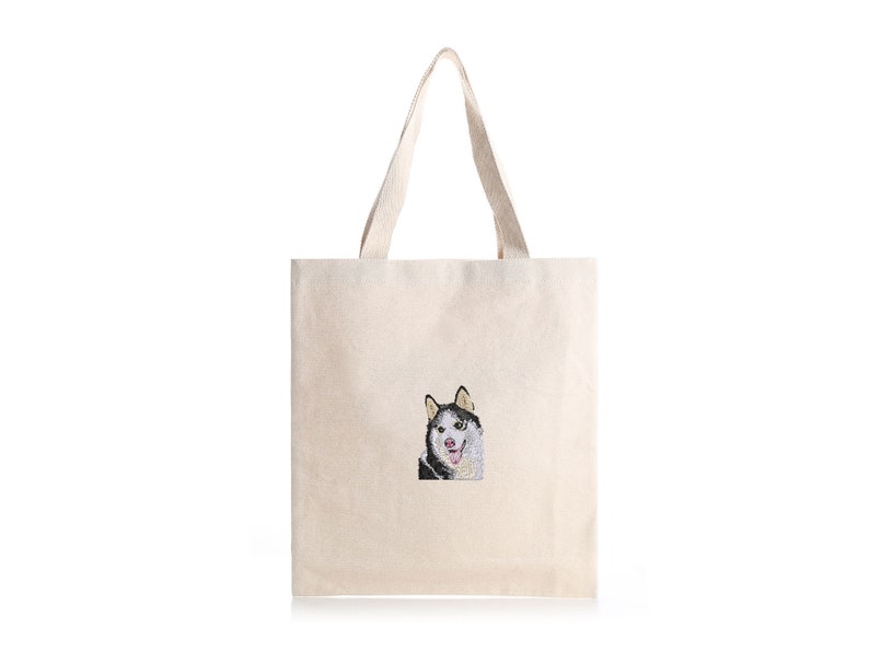May include: A white canvas tote bag with a black and white embroidered image of a husky dog.