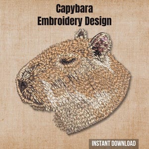 May include: An embroidery design featuring a side profile of a brown and tan capybara head. The text "Capybara Embroidery Design" is printed in black above the animal, and "INSTANT DOWNLOAD" is printed in white at the bottom right corner.