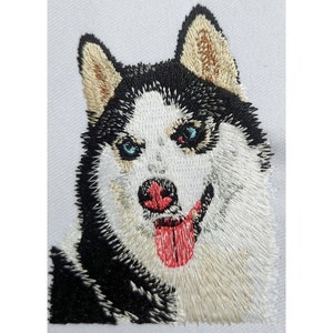 May include: Close-up of an embroidered husky dog with blue eyes, a pink tongue, and black and white fur.