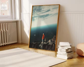 May include: A framed print of a surreal landscape with a person standing on a cliff overlooking a vast blue expanse. The sky above is a swirling mix of blue and white clouds.