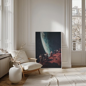 Op de afbeelding: Een surrealistische kunstprint met een groep mensen die op een rood, rotsachtig oppervlak staan ​​en uitkijken naar een grote, blauwe planeet in de verte. De planeet wordt omringd door een donkere, sterrenhemel.
