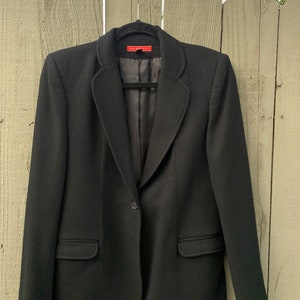 May include: A black blazer with a single button closure and a red label that reads "Hall-Mark 100%".