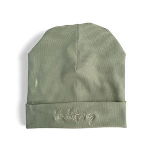 Könnte beinhalten: Salbeigrüner Rippstrick-Beanie mit dem gestickten Wort "Wildfang" in weißer Schrift über dem umgeschlagenen Bund. Der Hut besteht aus einem weichen, dehnbaren Material und ist so konzipiert, dass er eng am Kopf anliegt.