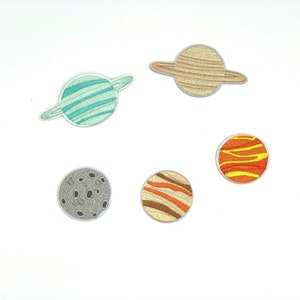 May include: A set of six embroidered iron-on patches featuring planets from our solar system. The patches are in various colors, including blue, green, orange, yellow, and brown. The planets are depicted with rings, craters, and stripes.