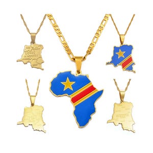 May include: A collection of gold-toned necklaces featuring map-shaped pendants. Some pendants display the flag of the Democratic Republic of the Congo in blue, red, and yellow, while others are engraved with regional maps and text labels.