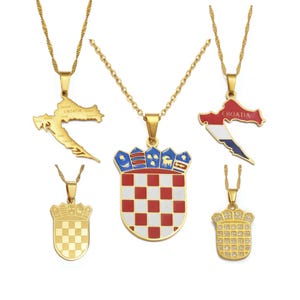 Peut inclure: Cinq colliers dorés sur le thème de la Croatie. Deux pendentifs représentent la carte de la Croatie, dont un avec le texte Croatia. Deux pendentifs sont des écussons à damier rouge et blanc, dont un avec des cristaux. Un grand pendentif central.