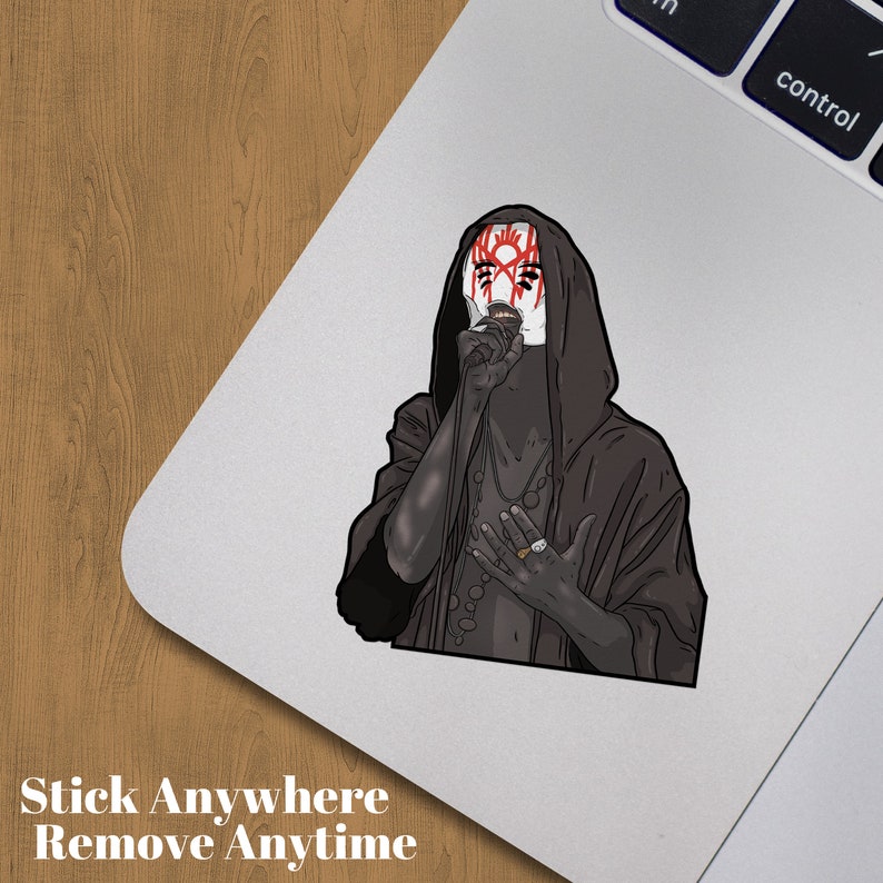 May include: A sticker depicting a figure in a black hooded robe and a white mask with red markings. The sticker has the text "Stick Anywhere Remove Anytime" at the bottom.