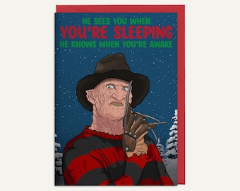 May include: Greeting card featuring a cartoon illustration of a character with a hat and bladed glove. The character is set against a snowy night scene with text that reads "HE SEES YOU WHEN YOU'RE SLEEPING HE KNOWS WHEN YOU'RE AWAKE."