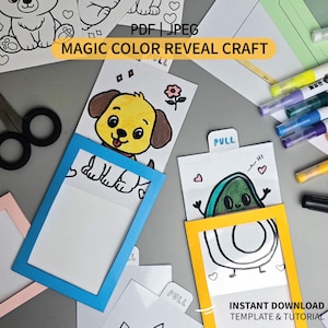 May include: A magic color reveal craft kit featuring paper templates with cartoon illustrations of a dog and an avocado. The set includes blue and yellow paper frames, markers in various colors, and scissors. Text reads MAGIC COLOR REVEAL CRAFT.