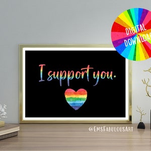 Puede incluir: Descarga digital imprimible de una impresión en blanco y negro con el texto "Te apoyo" y un corazón arcoíris. La impresión está enmarcada en un marco dorado y está sobre una mesa de madera.