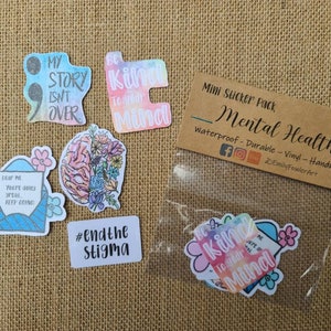 May include: A pack of mini stickers with mental health awareness themes. The stickers feature watercolor designs with phrases like "My story isn't over", "Be kind to your mind", and "#endthestigma".