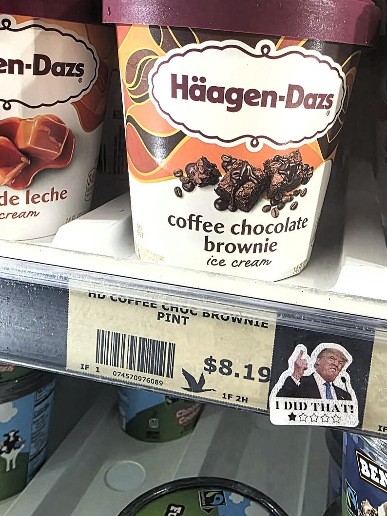 K&ouml;nnte beinhalten: Ein Pint H&auml;agen-Dazs Kaffee-Schokoladen-Brownie-Eis. Der Beh&auml;lter hat einen braunen Deckel und ein Etikett mit dem Markennamen und einem Bild von Brownies und Kaffeebohnen. Ein Preisschild darunter.