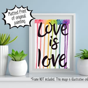 May include: A framed print with a rainbow background and the text "Love is love" in black lettering.