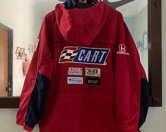 May include: Red hooded jacket with a blue and white "CART" logo on the back. The jacket has several sponsor patches, including "Target Chip Ganassi Racing", "Tasman", "Walker", and "Kodi". The jacket also has a Honda logo on the right sleeve.