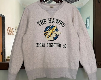 May include: A grey sweatshirt with a graphic of a plane and the text "THE HAWKS 314TH FIGHTER SQ" printed on the front.