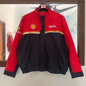 May include: Red and black jacket with a Shell Helix logo and a Ferrari sponsor logo. The jacket has a zip fastening and a stand-up collar.