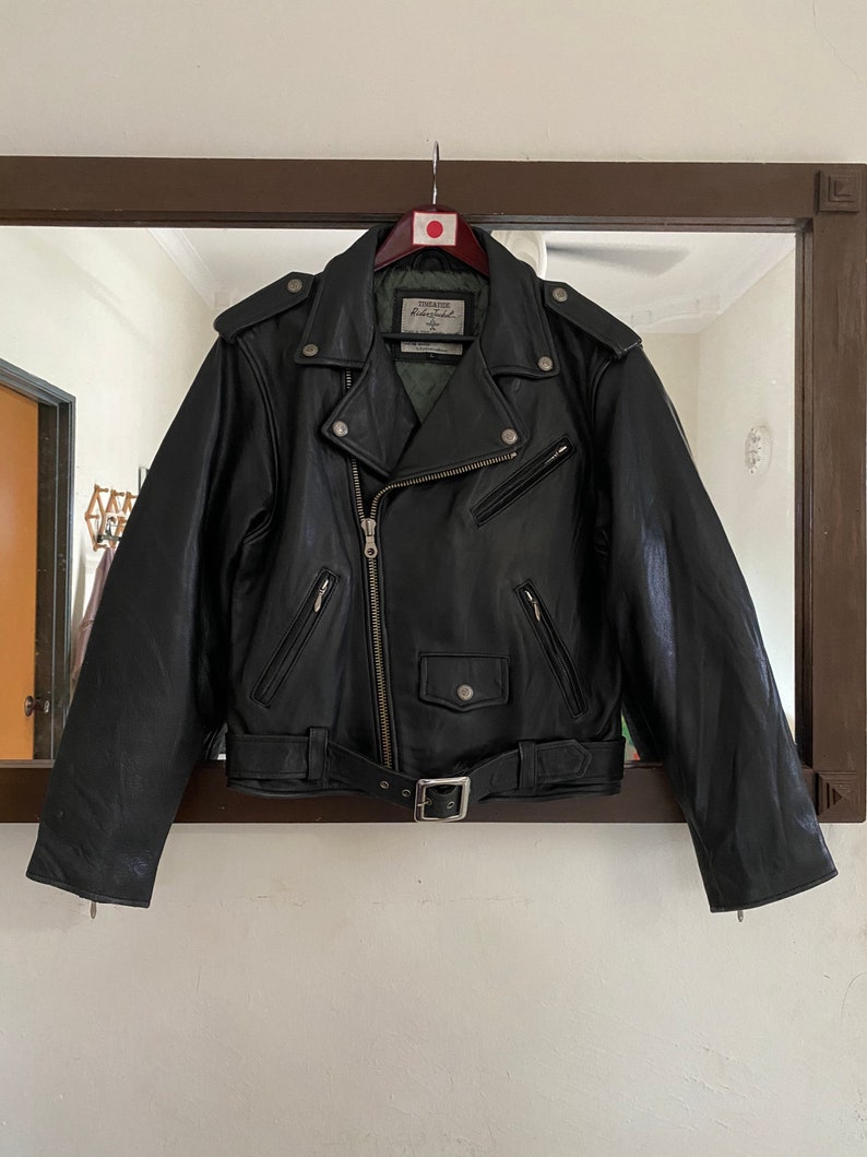 May include: Black leather motorcycle jacket with a zipper closure, a belt, and multiple pockets.