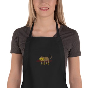 May include: Black kitchen apron with a brown monkey sleeping on a branch embroidered on the front.