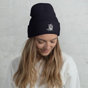 Peut inclure: Un bonnet noir avec un motif de chien husky brod&eacute; en blanc et gris. Le bonnet est fait d'un mat&eacute;riau doux et chaud, id&eacute;al pour les temp&eacute;ratures froides.