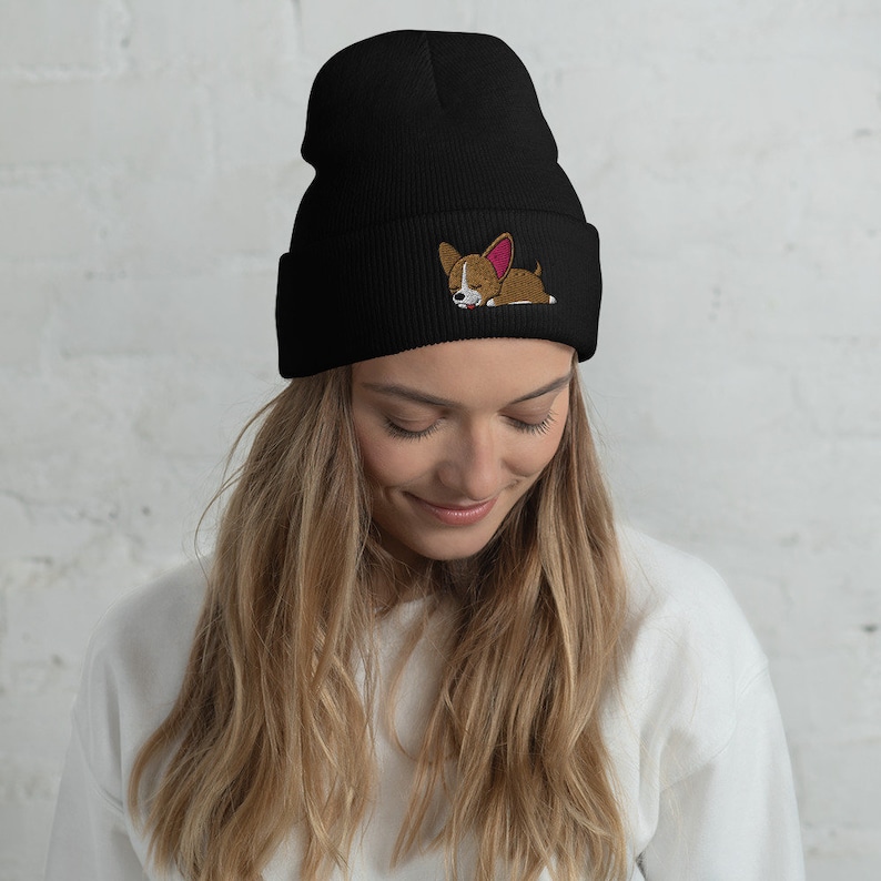 May include: Black beanie with a brown and white sleeping dog embroidered on the front.