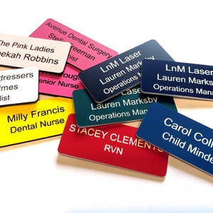 May include: A collection of colourful name tags with black text. The name tags are made of plastic and have rounded corners. The text on the name tags includes names, job titles, and business names. Some of the text includes: "The Pink Ladies", "Rebekah Robbins", "Jayne's Hairdressers", "Karen Holmes", "Head Stylist", "Milly Francis", "Dental Nurse", "LnM Laser", "Lauren Marksby", "Operations Manager", "Stacey Clement", "RVN", "Carol Collins", "Child Minder".