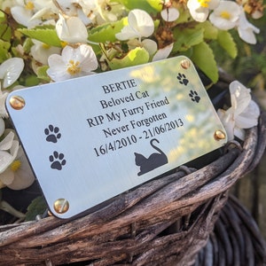 Puede incluir: Placa conmemorativa plateada con el nombre "BERTIE" y el texto "Beloved Cat, RIP My Furry Friend, Never Forgotten, 16/4/2010 - 21/06/2013". Tiene huellas de patas y una silueta de gato.