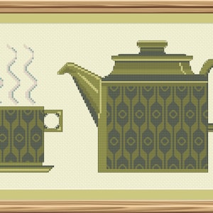 May include: A green teacup and teapot with a geometric pattern. The teacup has steam rising from it.