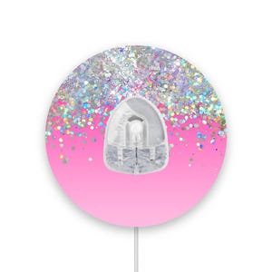 Peut inclure: Un autocollant rond rose et argenté à paillettes avec un crochet en plastique transparent au centre. L'autocollant est parfait pour décorer les murs, les ordinateurs portables ou d'autres surfaces.