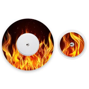 Puede incluir: Un parche redondo, blanco y adhesivo con un diseño de fuego. Las llamas son de color naranja, amarillo y rojo. El parche tiene un pequeño botón redondo plateado en el centro.