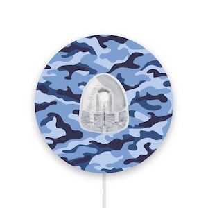 May include: A round, blue and black camouflage mouse mat with a white cord. The mouse mat has a clear, plastic mouse on top.